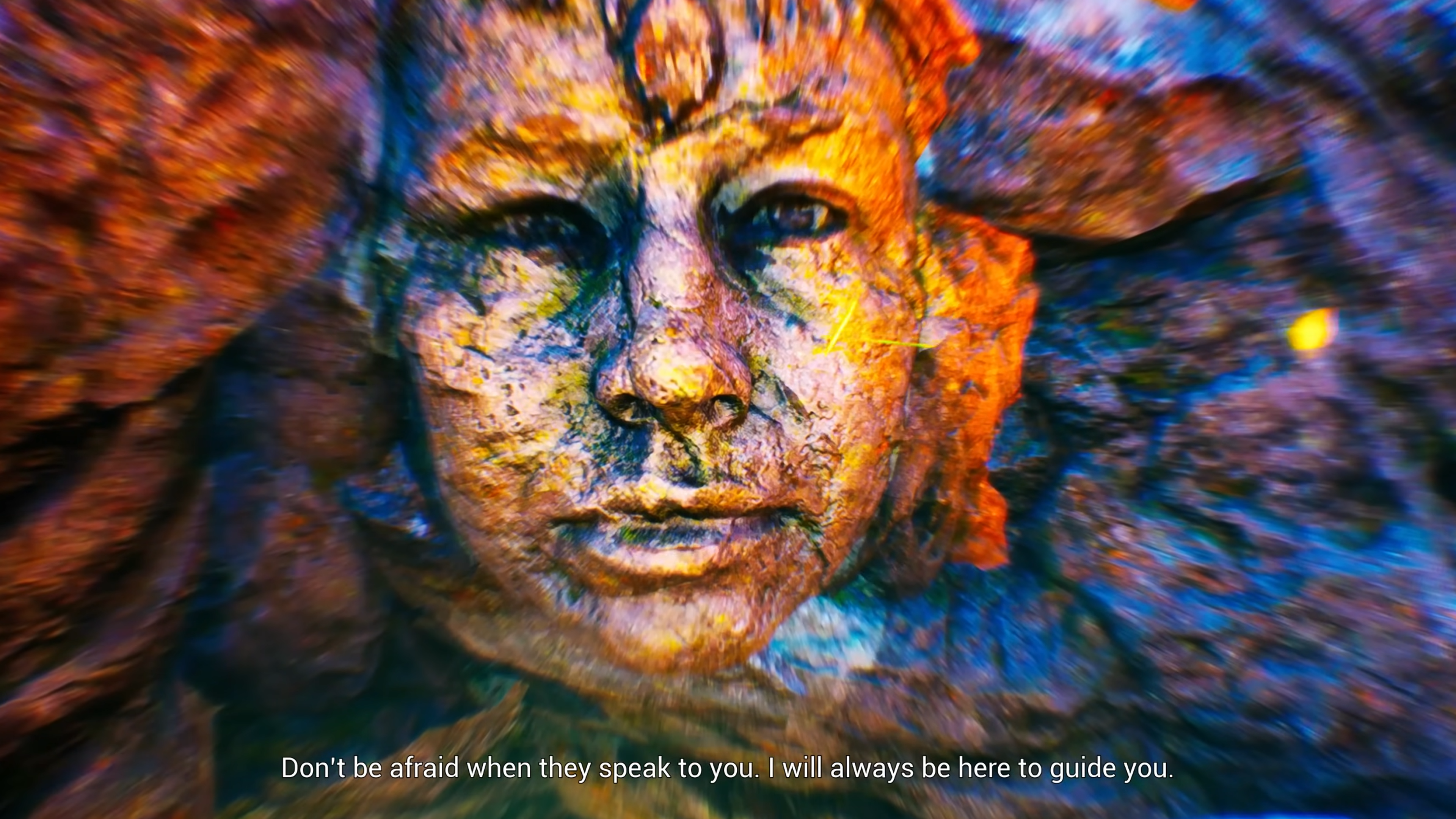 An image of rocks, slightly blurry as if the viewer is in motion. In the center is a face that also looks to be made of rock except for its blue-grey eyes peering out of the stone. A caption reads "Don't be afraid when they speak to you. I will always be here to guide you."